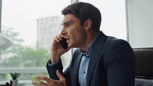 Frustrated man arguing on the phone in office