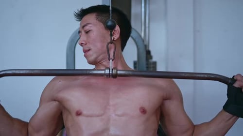 Young men lift weights in the gym to gain muscle mass.