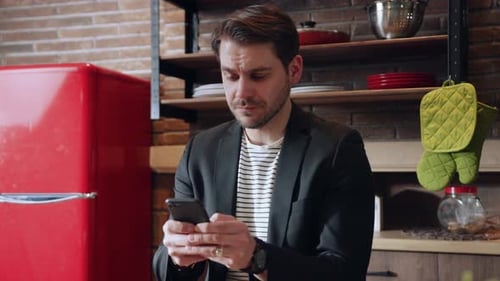 Man Using Mobile Phone Indoors in Kitchen