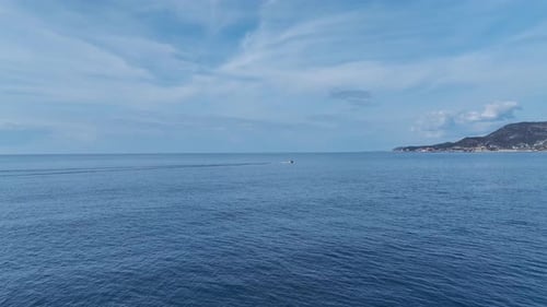 Aerial Video of a FastMoving Boat on the Open Sea Creating Waves As It Speeds Towards the Harbor