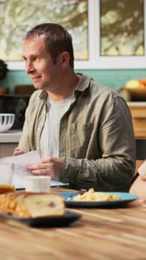 Vertical Video Distracted Busy Father Studying Some Papers During Breakfast Meal