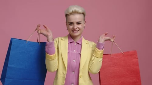Blonde Woman Posing with Shopping Bags on Pink