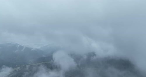 Aerial View of Rolling Mountain Landscape Above Clouds