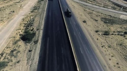 Uma vista de cima de uma rodovia da cidade, veículos pesados e outros em movimento.