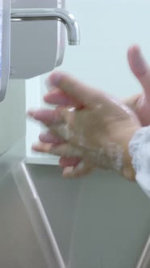 Hands Washing With Soap At Stainless Steel Sink