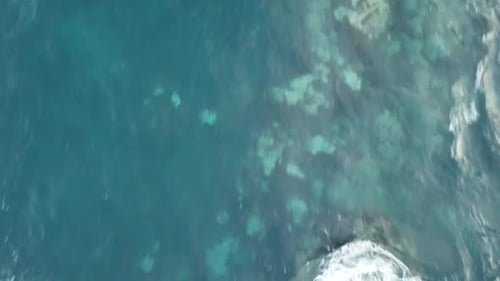 Aerial View of Ocean Waves Crashing on Shore