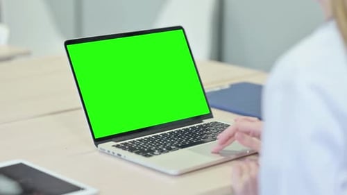 Young Woman Working on Laptop with Green Chroma Screen
