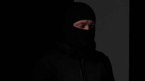 Man Wearing Ski Mask in Dark Setting