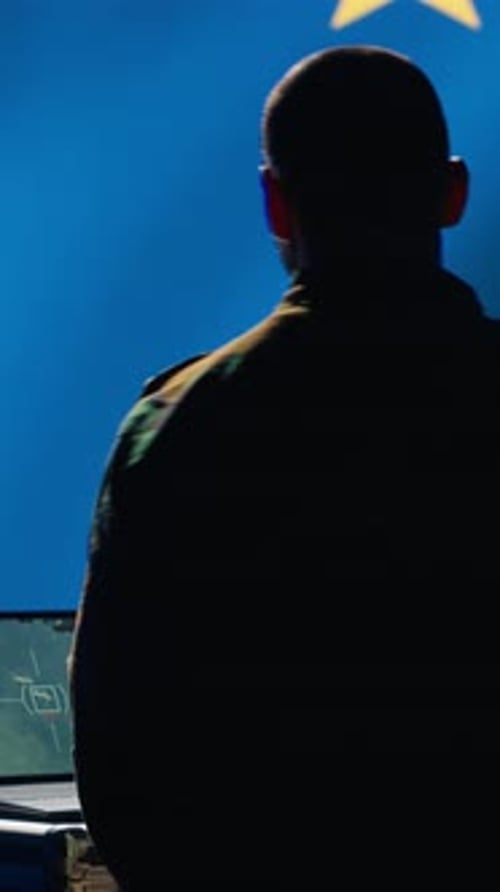 Man Working on Laptop in Front of EU Flag