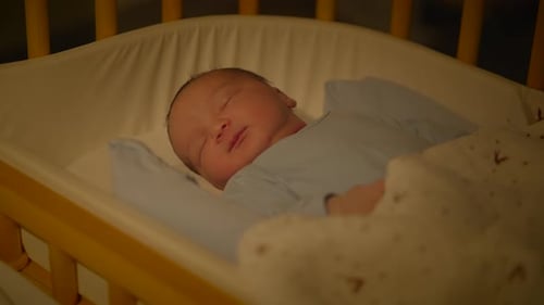 Infant Sleeping Soundly in a Wooden Crib at Night