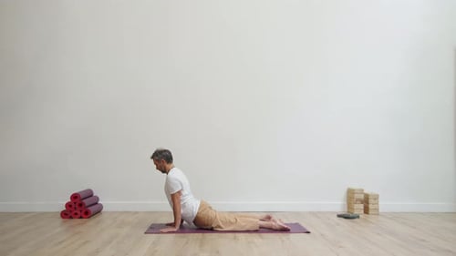 Man Practicing Yoga Pose on Mat Indoors