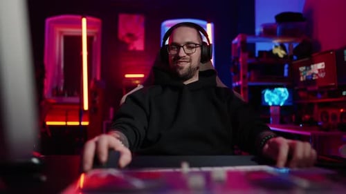 Male Gamer Using Computer in Neon Lit Room