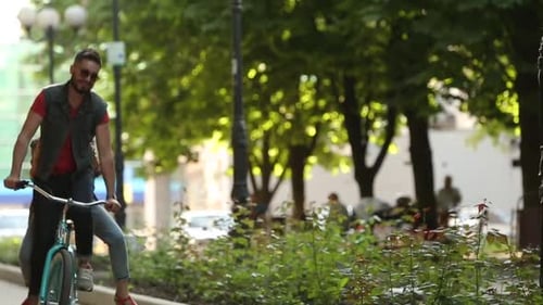 Jovem casal andando de bicicleta juntos no parque Namorado romântico andando de bicicleta com namorada feliz