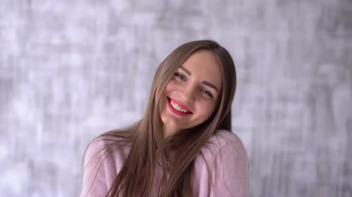 Happy Woman Smiling and Laughing in Front of Wall