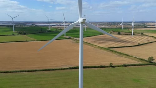 Drone aerial footage of renewable energy wind turbine generating green electricity over