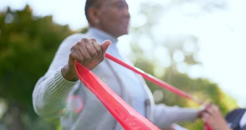 Senior Woman Exercises with Resistance Band in Park