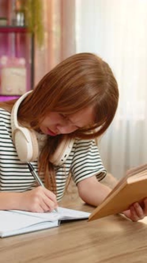 Child Girl Kid Confused By School Textbook Task at Table on Home Sofa Holding Head with Frustration