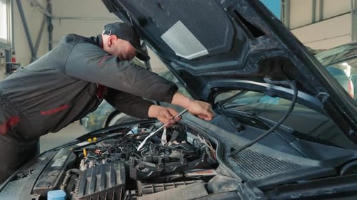 A Mechanic Repairs a Car Engine