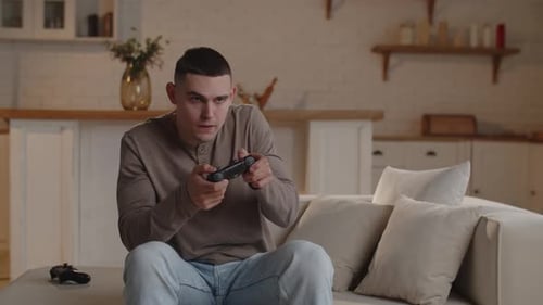 Young Man Playing Video Game on Sofa