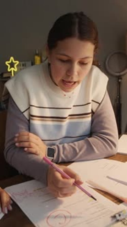 Teen Girl and Her Tutor Sitting at Desk during Lesson