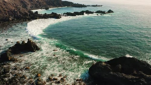 Pristine Volcanic Calm Ocean Beach Waves Crashing on Sand and Stones Rocky Shore