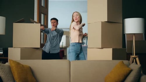 Excited Couple Dancing in New Home Surrounded by Boxes