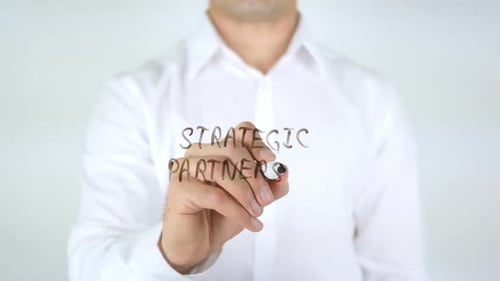 Man Writes Strategic Partnership on Clear Surface