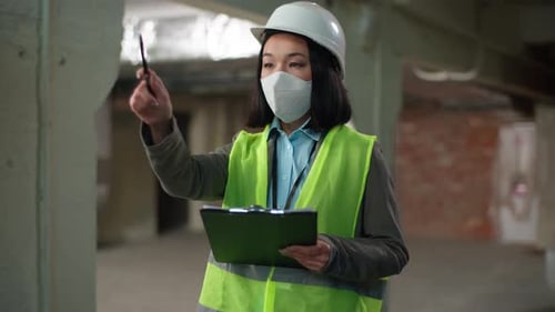 Asian Japanese Woman Builder in Safety Mask Hold Tablet Pointing Counting Checking Building Plan
