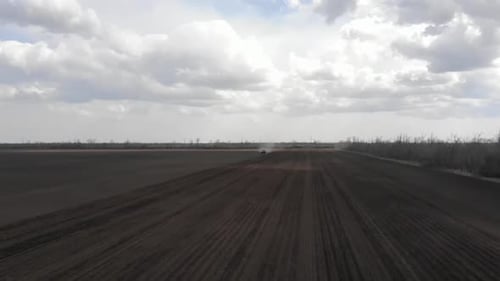 Blue tractor working on the field in Odessa in Ukraine during planting sunflower