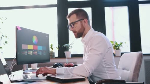 Young Adult Graphic Designer Working at Computer