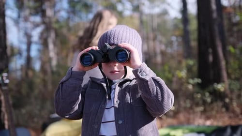 Child Using Binoculars in a Forest