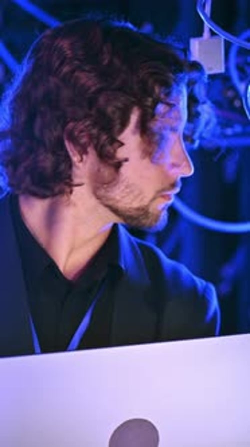 Young Man Working on Laptop with Blue Lighting