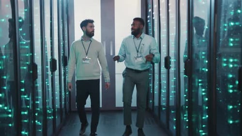 Two Men Discuss Data Management in a Hightech Server Room