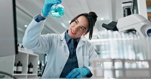 Female Scientist Examining Blue Liquid in Lab