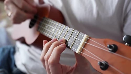 Ukulele Strings Strummed by Fingers Playing Music