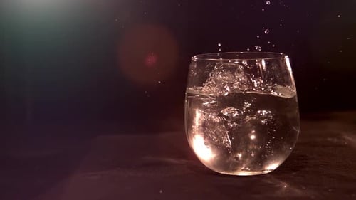 Ice Cubes Dropping into Glass of Water