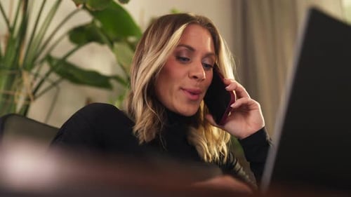 Woman Talking on Cell Phone While Using Laptop