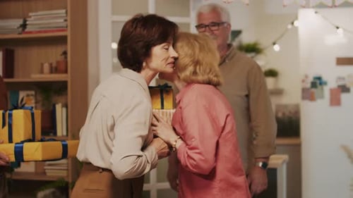 Mature Adults Exchanging Birthday Gifts at Party