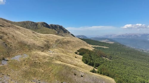 Flight over beautiful mountain peaks covered with grass. Mountain from above on a sunny autumn day.