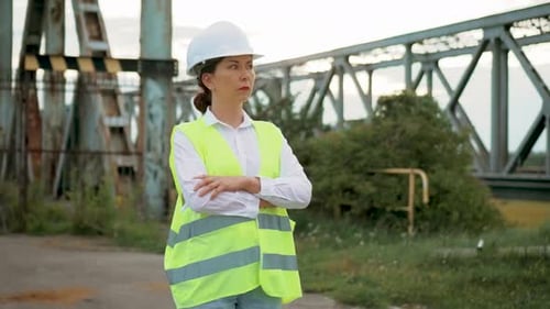 Female Engineer Standing By Railroad With Passing Train
