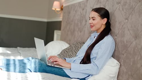 Charmante Frau im Schlafzimmer Videoanrufe vom Hotel Smiles Greets Friend Laptop