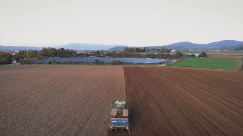 Agricultural work in field. Tractor harrowing land at countryside