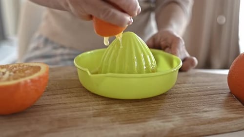 Woman Making Fresh Orange Juice at Home