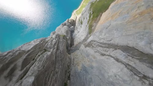 Un Zumbido FPV que se zambulle por un acantilado sobre un lago de gran altitud en Suiza