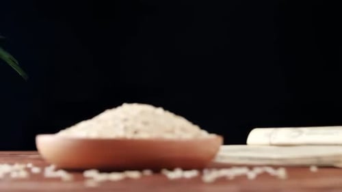 Wooden Bowl of Rice Grains Filling Up