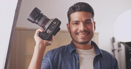 Professional male photographer working in studio. Photographer shooting model with flashlight.