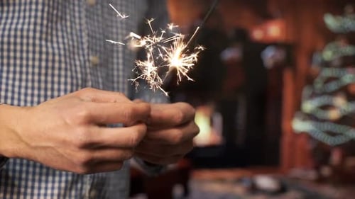 Person Holding Sparklers at Christmas Celebration