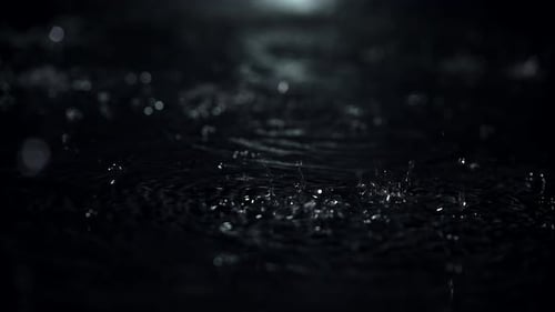 Superzeitlupenvideo von Regentropfen mit 1000 Bildern pro Sekunde auf schwarzem Hintergrund, Wasserfall, aufgenommen mit 1000 Bildern pro Sekunde