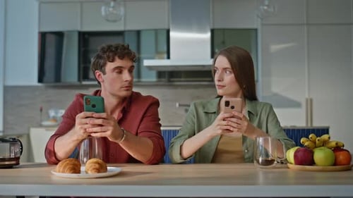 Young Adults Using Smartphones at Kitchen Table