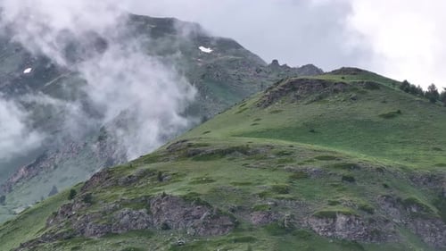 Clouds are Moving Over a Green Mountain Peak